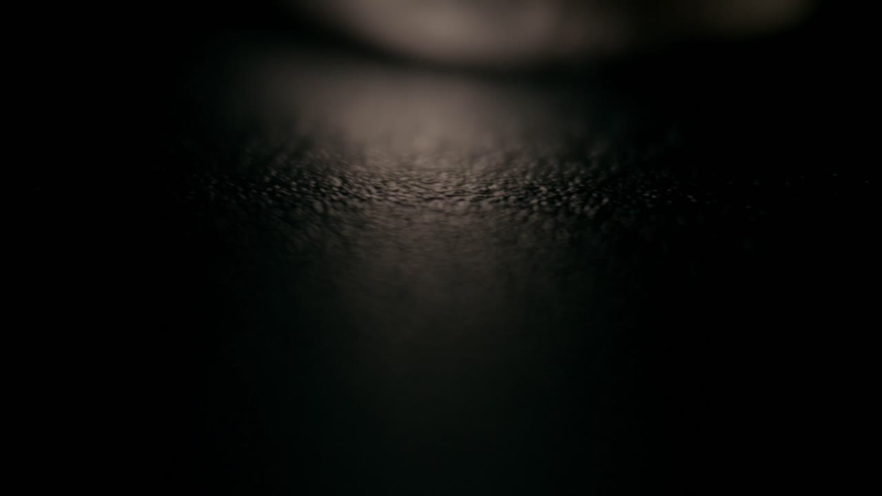 Close-up shot of intertwined metal rings on a textured, dark background, showcasing intricate surface details and a warm, intimate ambiance under soft, diffused lighting