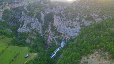 aerial drone view ujevara e sotires wild waterfalls in nivica canyon with cliffs of karst gorge with pool