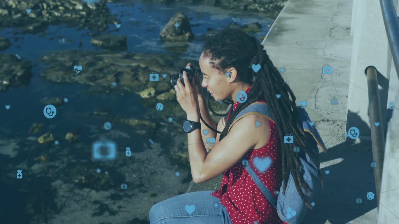 animación de una red de conexiones con iconos de bombillas sobre una mujer tomando fotos con una cámara