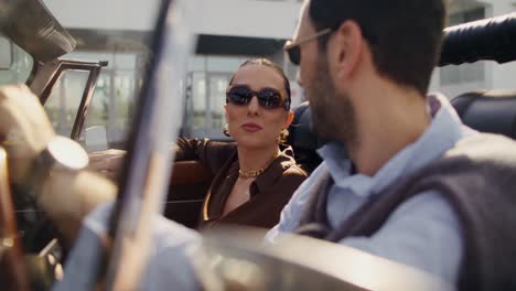 couple enjoying a ride in a vintage convertible