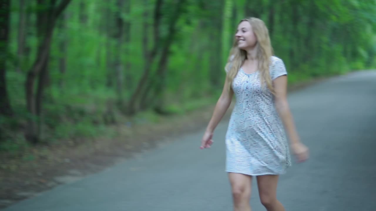 Young Couple Kissing On The Road. Pretty young couple in love having fun on the forest road