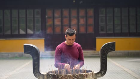 Europäischer-Mann,-Der-Ein-Brennendes-Räucherstäbchen-In-Einem-Chinesischen-Tempel-Platziert