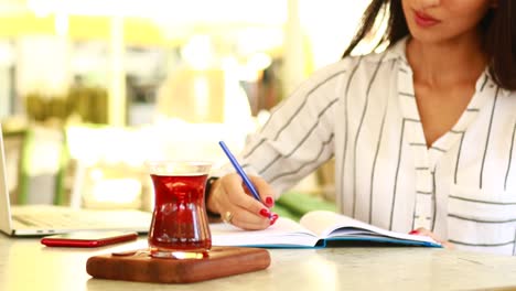 mujer de negocios asiática ocupada trabajando en una computadora portátil en un café de verano al aire libre en una playa tropical