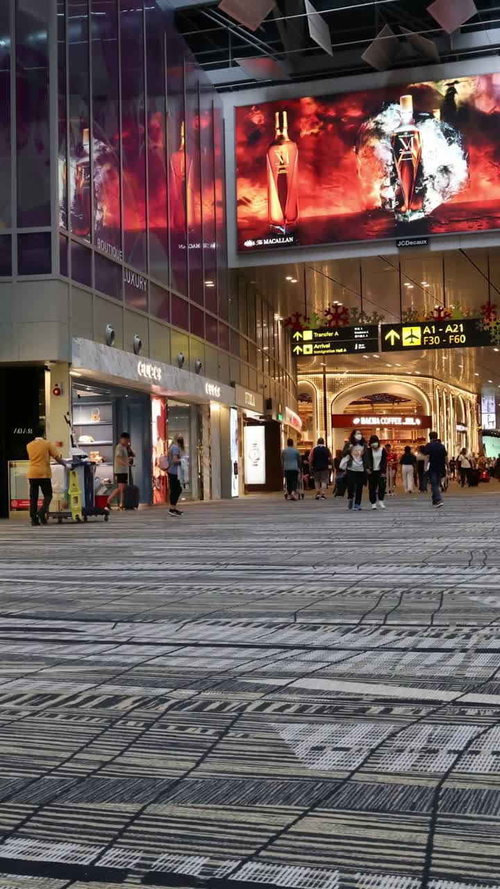 바쁜 쇼핑몰 복도를 걸어가는 쇼핑객 들