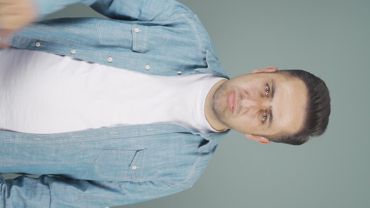 vídeo vertical del hombre mirando a la cámara con una expresión negativa.