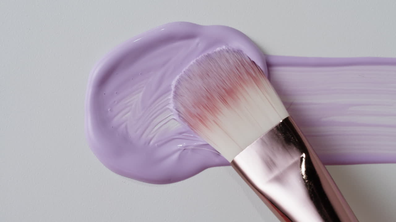 Makeup Brush Applying Purple Cosmetic Cream