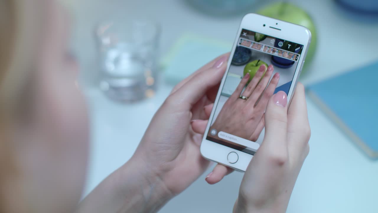 mano sosteniendo teléfono móvil con anillo video de mano