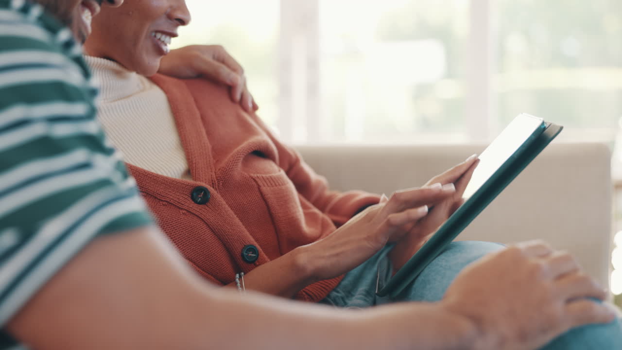 Happy couple on sofa with tablet