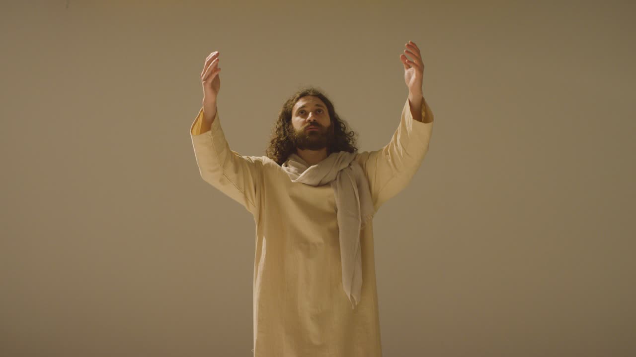 retrato de un hombre vestido con túnicas con cabello largo y barba que representa la figura de jesucristo levantando las manos en oración 2