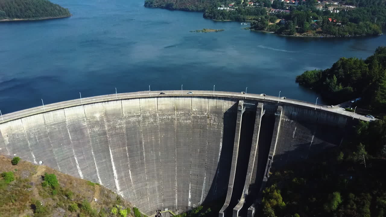 Cars driving through Dam located in Montalegre, Portugal - Drone shot aerial view forward.