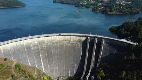 cars driving through dam located in montalegre, portugal - drone shot aerial view forward.
