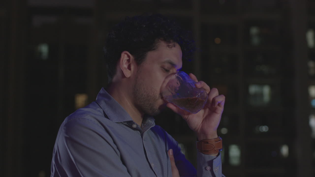 hombre de negocios atrapado en el pensamiento trabajando hasta tarde en la noche bebiendo licor fuerte