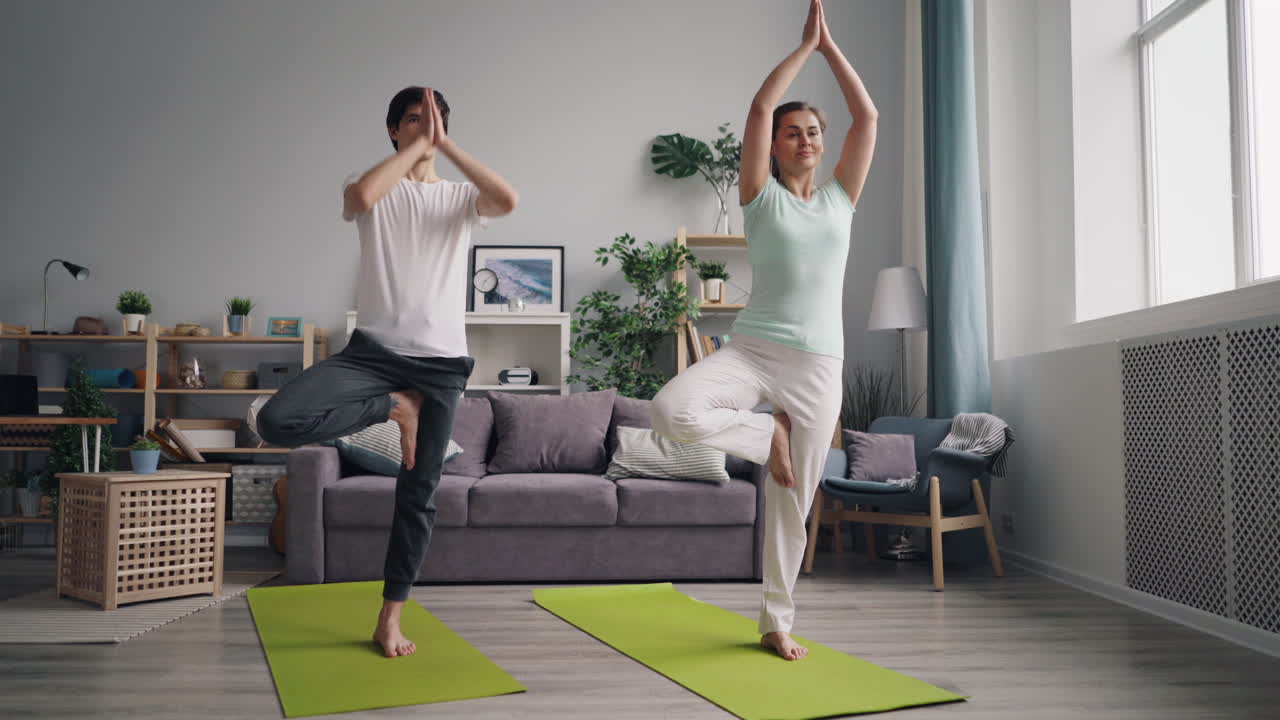 pareja practicando yoga en casa