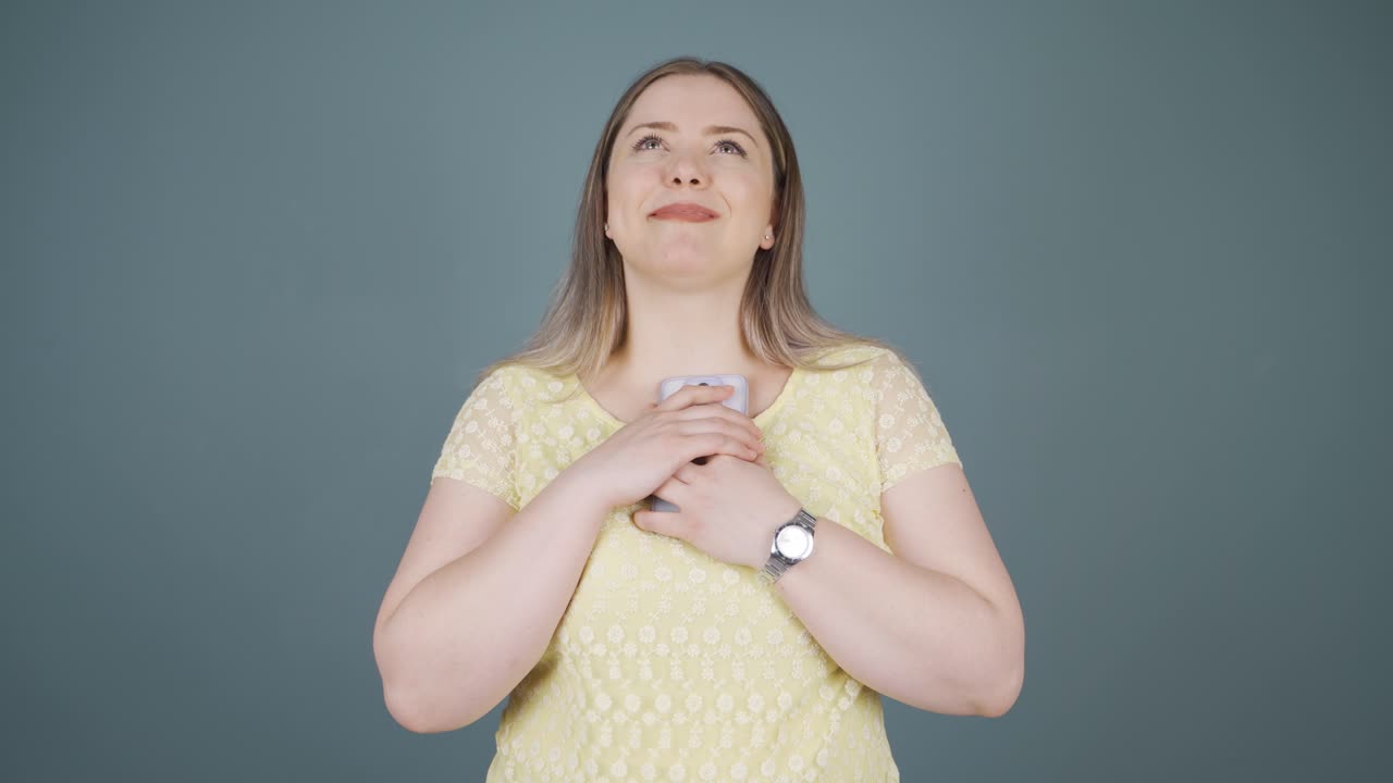 la joven que felizmente pone el teléfono a su corazón.