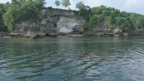 low altitude dolly drone shot of polluted water filled with floating trash in the turqouise tropical water of bali indonesia