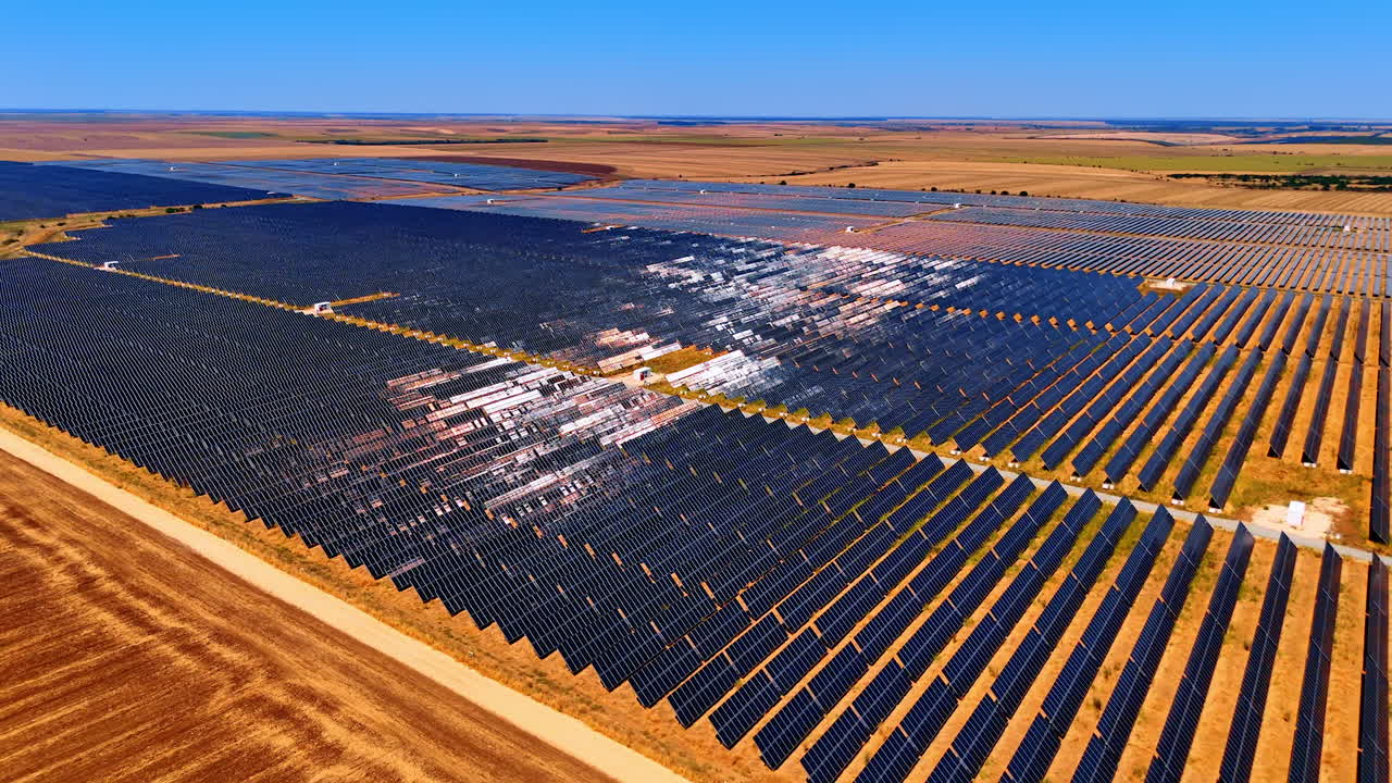 Multiple solar panels cover fields in the countryside. Sustainable energy concept. Aerial view