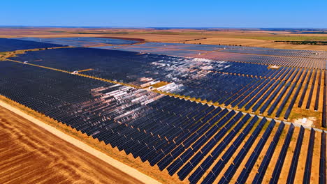 Multiple solar panels cover fields in the countryside. Sustainable energy concept. Aerial view