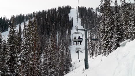 family on small two person chair telluride colorado way up the mountain fresh snow cinematic slow-motion scenic ski trails powder bumps rocky mountains aspen vail usa epic pass snowboard ski resort