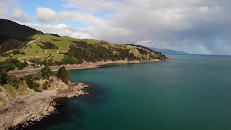 Aerial-view-beautiful-turquoise-clear-water-on-a-cloudy-day,-New-Zealand-coastline