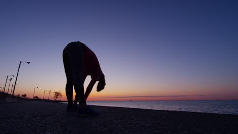 flexible hispanic caucasian female silhouette stretching at sunrise