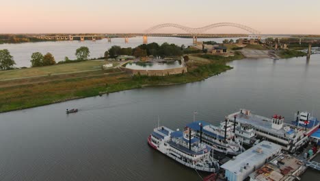 aerial view above small fishing boat passing along the mississippi river with docked paddle boats