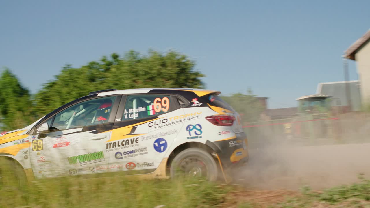 Rallye auto projíždějící ostrou zatáčkou zpomaleně