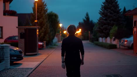 young man walking in middle peacefully on empty street at evening time