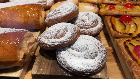 freshly baked pastries with powdered sugar on a wooden surface