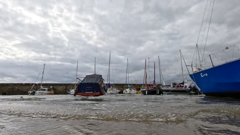 día nublado con barcos y olas suaves