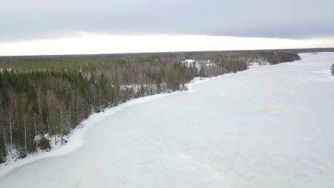 Luftiges,-Idyllisches,-Isoliertes-Ländliches-Dorf,-Umgeben-Von-Endlosen-Kiefern--Und-Fichtenwäldern-Und-Einem-Zugefrorenen-See,-Kalter-Winter-In-Skandinavien