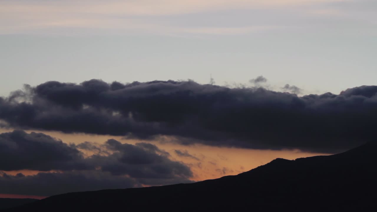 극적인 구름과 함께 산 위에 해가 지는 것