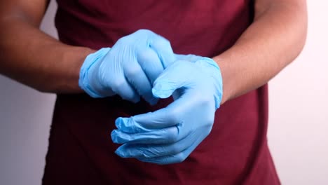 person putting on blue medical gloves