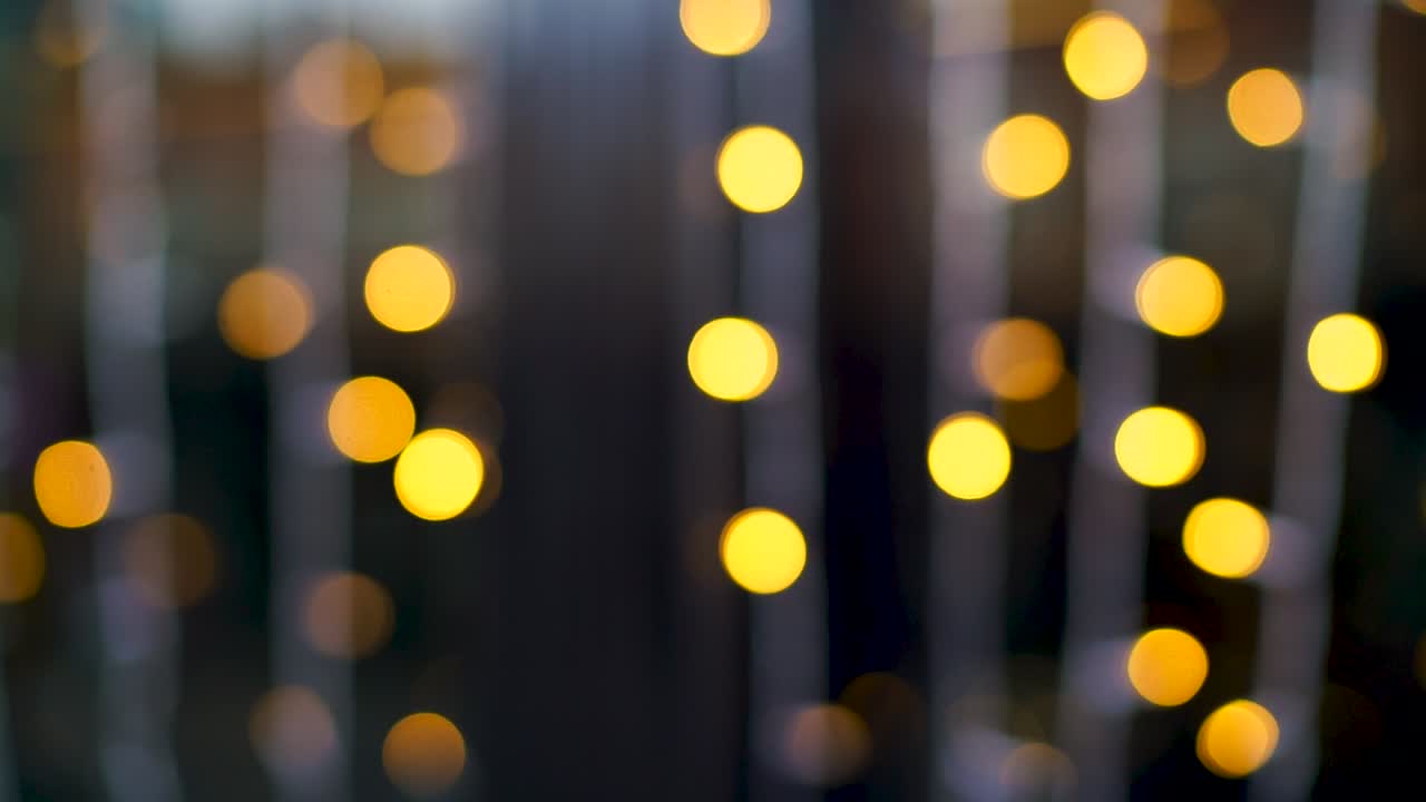 fuera de foco hebras de luces navideñas amarillas parpadeantes con un fondo azul creando un efecto bokeh mágico