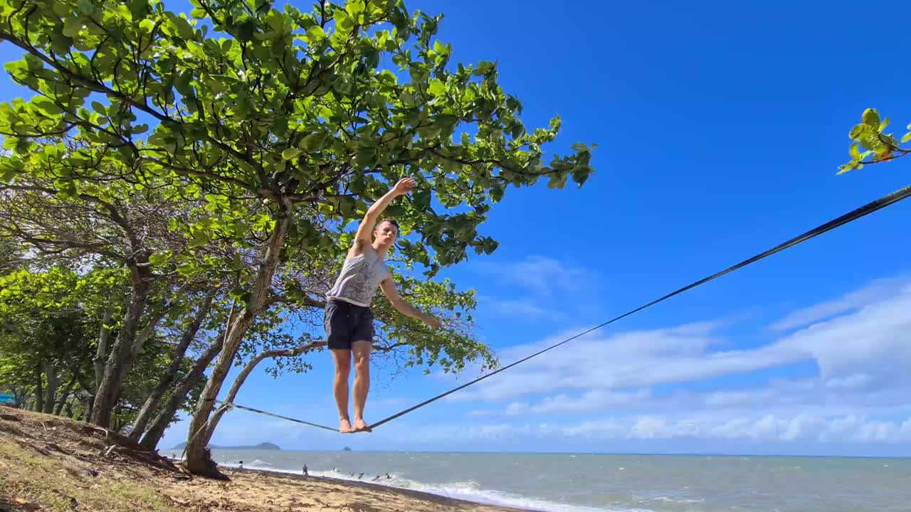 Young Adult Male On Slackline On Trinity Beach In Cairns
