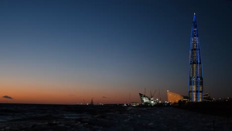 night view of the lakhta center skyscraper over the baltic sea during sunset.