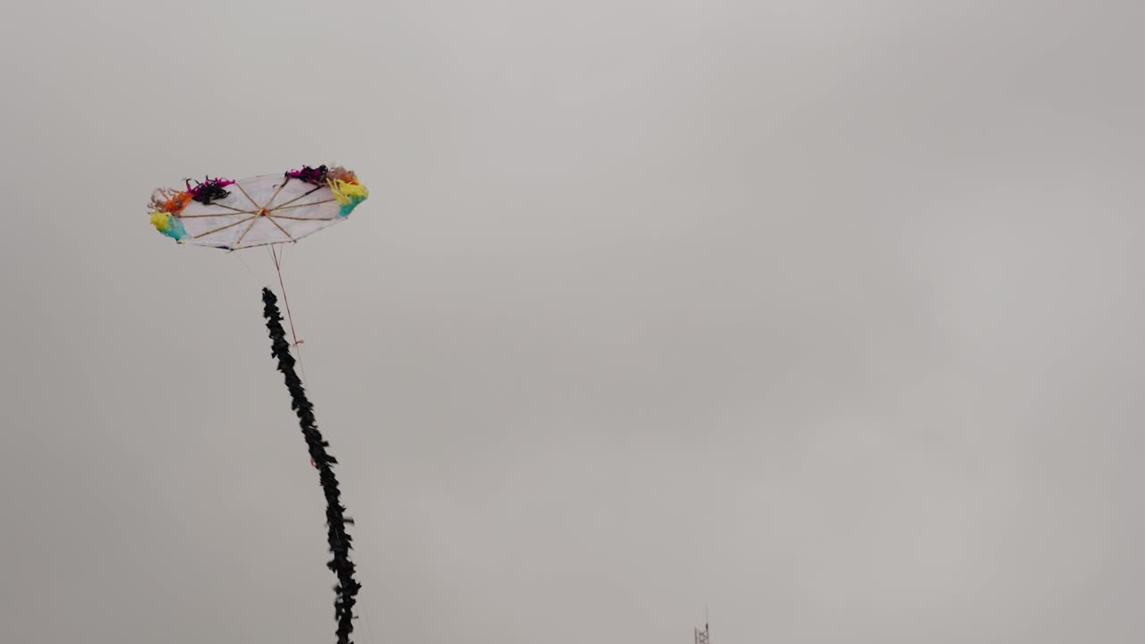 Colorful handmade kite flies high during Sumpango Giant Kite Festival in Guatemala