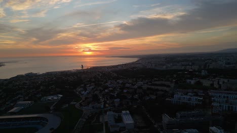 aerial view of a red-orange sunset over lisbon, portugal, with an abundance of clouds adding depth and texture to the vibrant evening sky