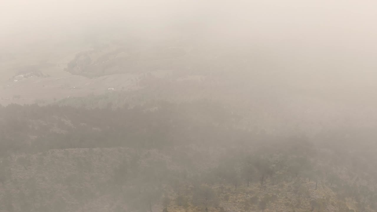 낮은 안개를 통해 엘 아주스코 언덕 꼭대기의 공중 전망과 함께 안개가 가득한 멕시코 풍경