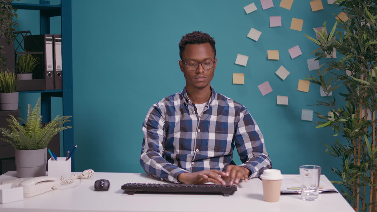POV of office worker typing on computer and looking at camera