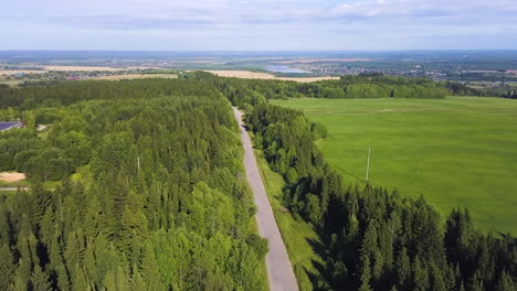 aerial view of a road winding through forest and fields