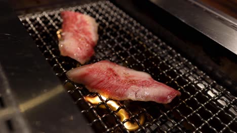 meat cooking over flaming charcoal grill