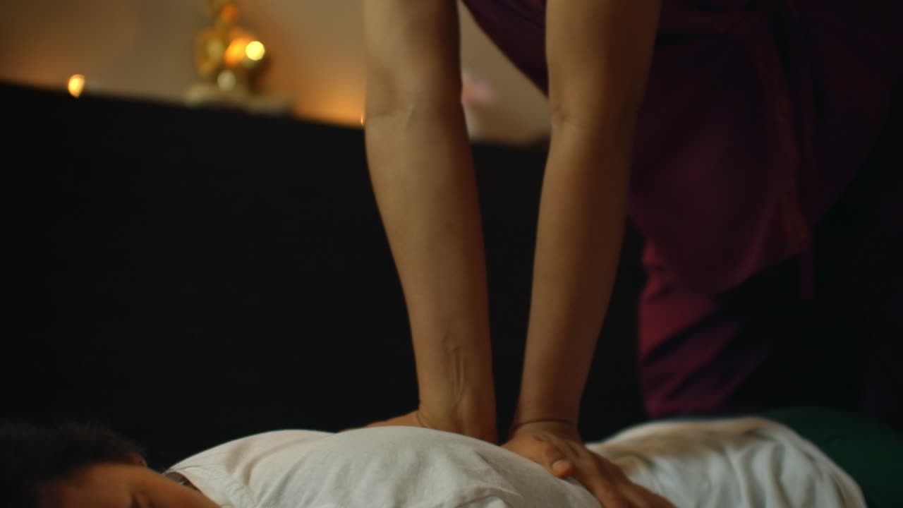 Terapeut giver traditionel kinesisk fodmassage. Professionel terapeut giver en kvinde traditionel kinesisk fodmassage i et kinesisk behandlingsmiljø