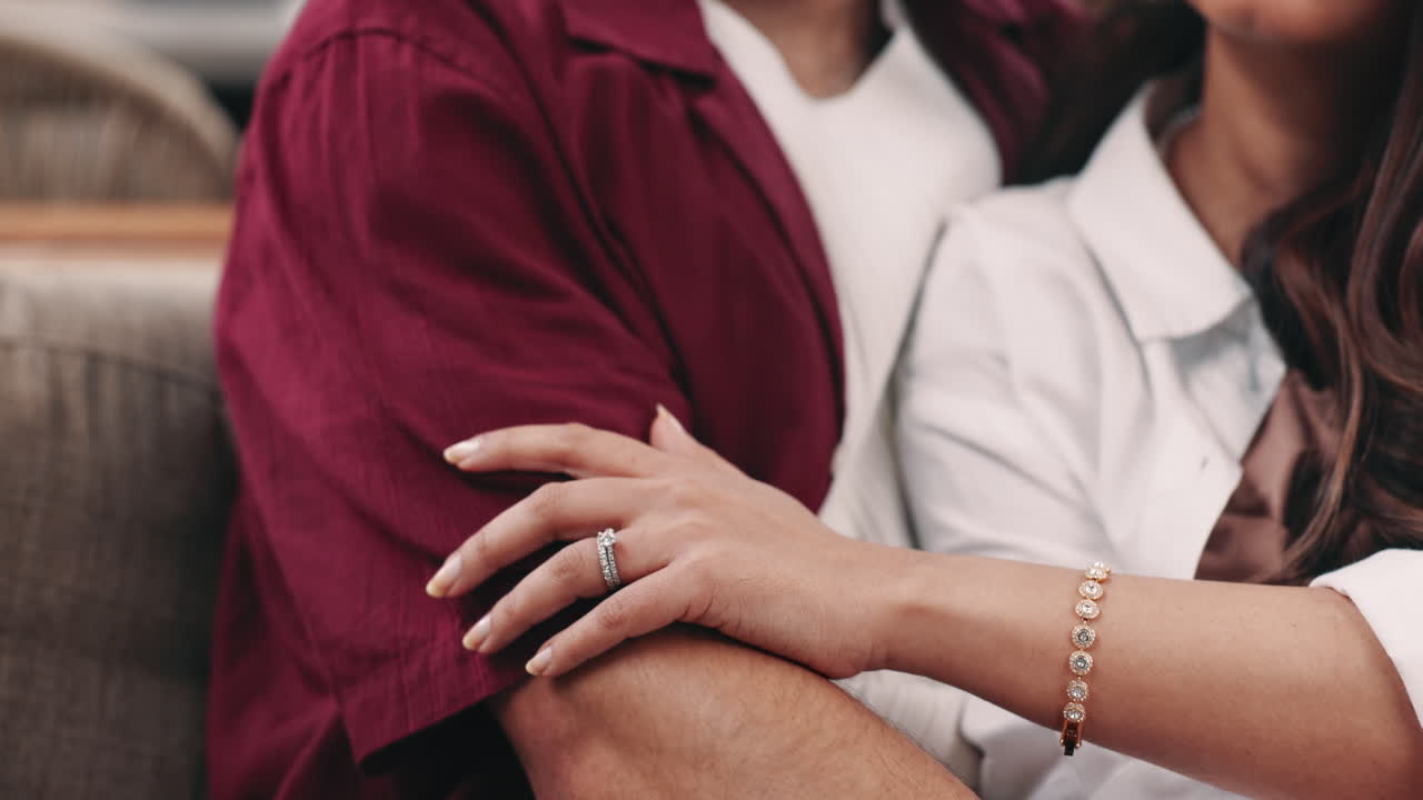 Close Up of Woman's Hand with Engagement Ring on Man's Arm