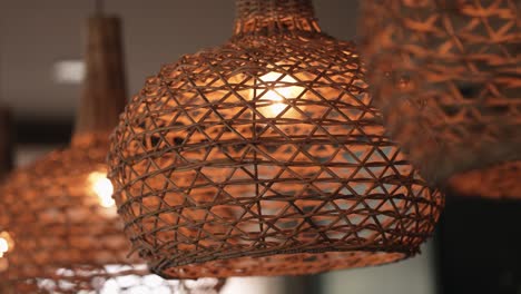 Close-up-of-illuminated-wicker-lampshades-with-intricate-wooden-lattice-designs