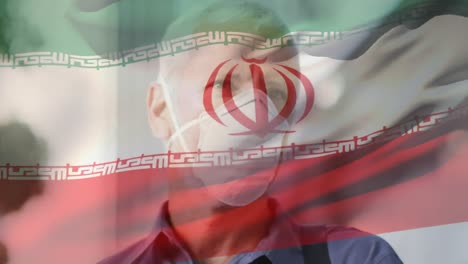 animación de la bandera de irán ondeando sobre un hombre caucásico con máscara facial en la calle de la ciudad