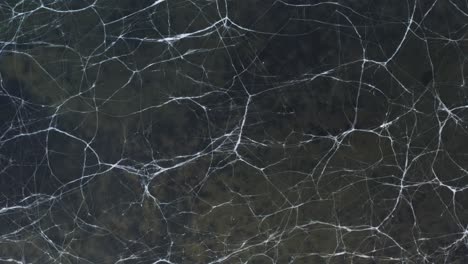 abstract lines in frozen surface of lake in iceland, seltjörn, aerial