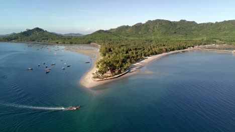 drone shot of local boat passing siwalai beach on koh mook tropical island in andaman sea in trang, southern thailand