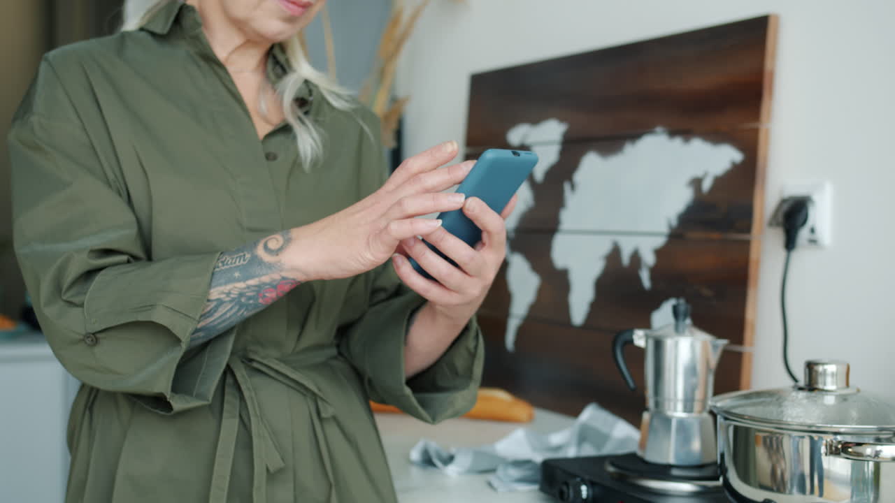mujer usando un teléfono inteligente en la cocina