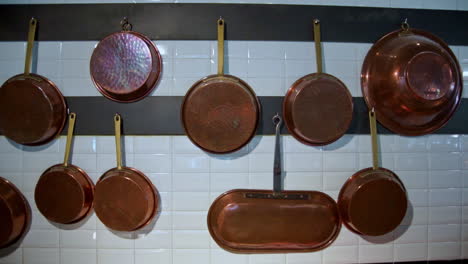 footage of copper pans hanging on a wall of an italian restaurant