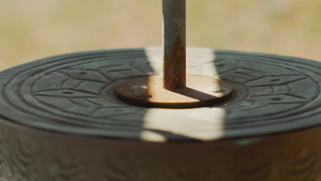 tranquil scene of a buddhist prayer wheel moving peacefully in a streak of shadow on a clear day